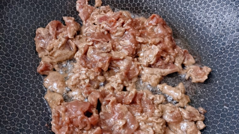 葱爆牛肉,起锅烧油倒入牛肉翻炒至变色，立马盛出来放入碗里  