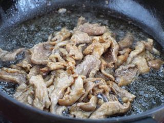 黄瓜炒木耳,锅中倒入食用油烧热，将腌制好的肉片刚进去翻炒至发白断生状态盛出。