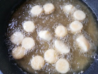金针菇豆腐煲,锅中宽油烧至5成热，将裹好淀粉的日本豆腐下油锅。