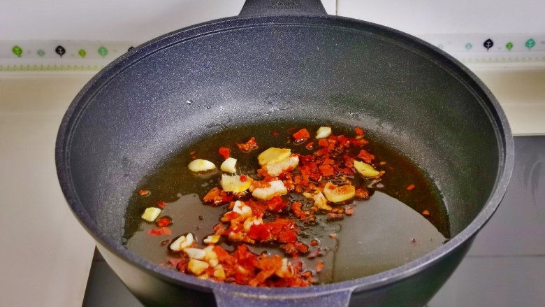 蒜苔炒鱿鱼,起油锅，加入姜蒜辣椒煸炒。