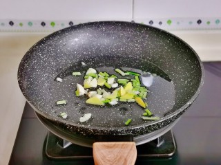 韭菜炒鱿鱼,起油锅加入切好的葱姜蒜，煸炒出香味儿。