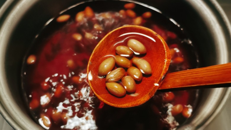 花生红枣汤,小火慢煮，汤水已经变成红色花生煮至体积增大。