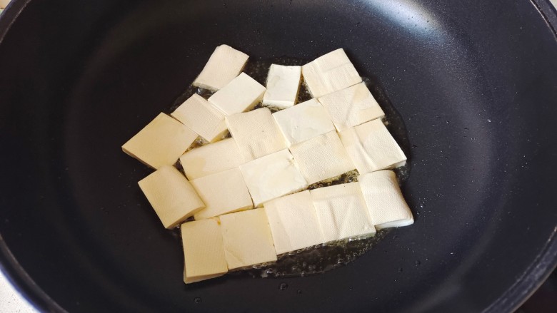 金针菇豆腐煲,放入豆腐块，小火慢慢煎至