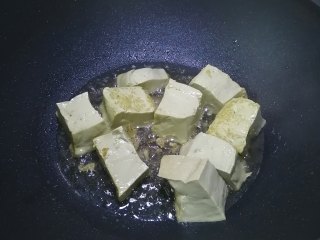 金针菇豆腐煲,热锅入油，加入豆腐煎至四面焦黄