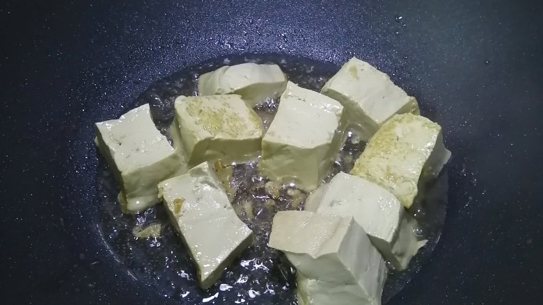 金针菇豆腐煲,热锅入油，加入豆腐煎至四面焦黄