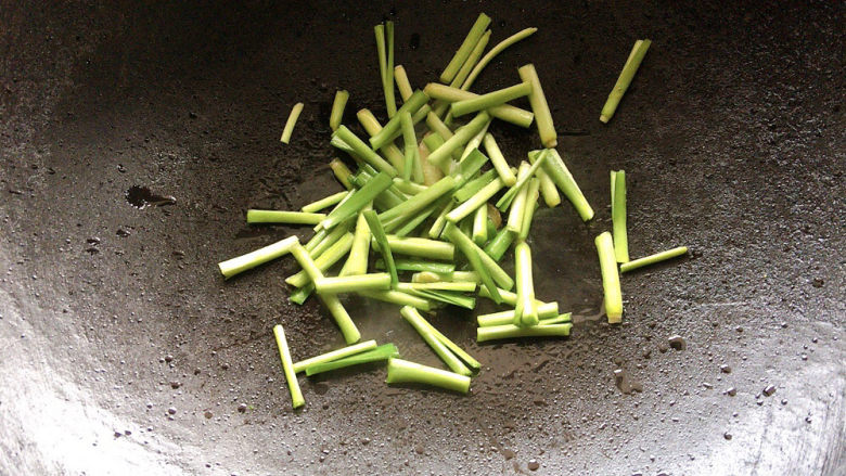 韭菜炒鱿鱼,加入韭菜根部，不易成熟的部分先行炒制。