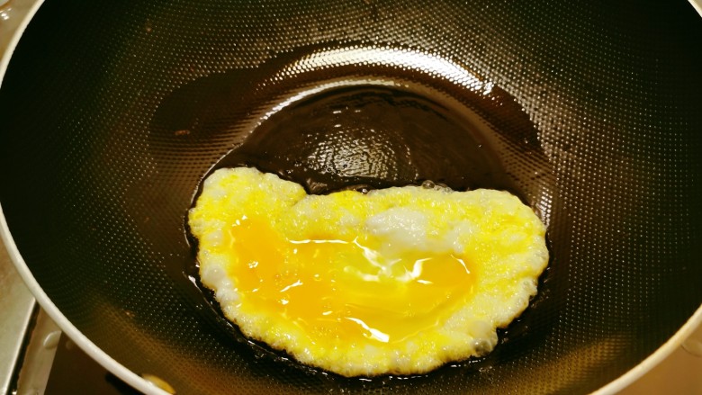 金针菇炒鸡蛋,起油锅放入食用油，油热后放入鸡蛋液。