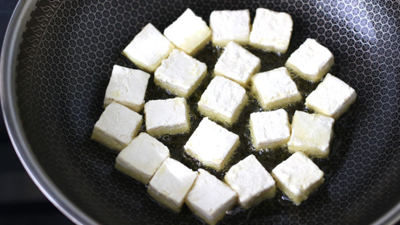 金针菇豆腐煲,油锅烧热后，放入豆腐小火慢慢煎至。