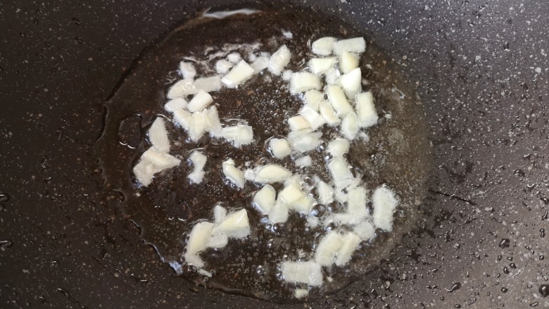 蚕豆炒鸡蛋,锅里继续倒油烧热，下入大蒜炒香。