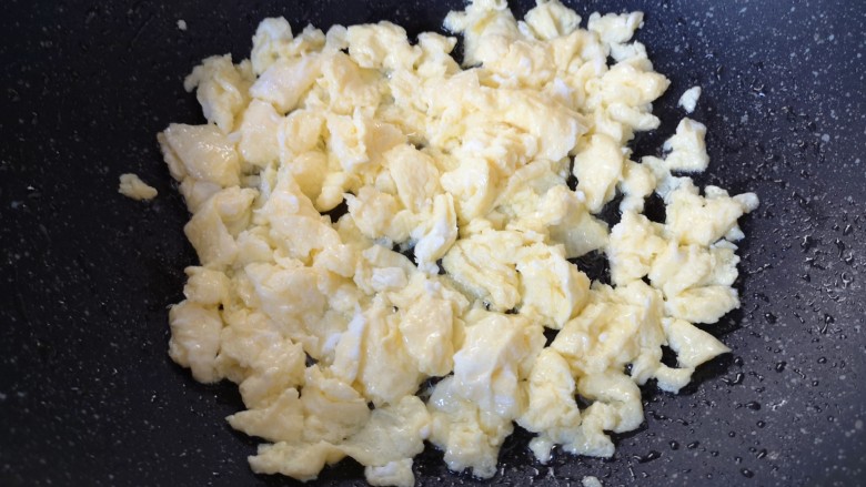 蚕豆炒鸡蛋,将鸡蛋炒熟后用铲子敲成小块，盛出备用。