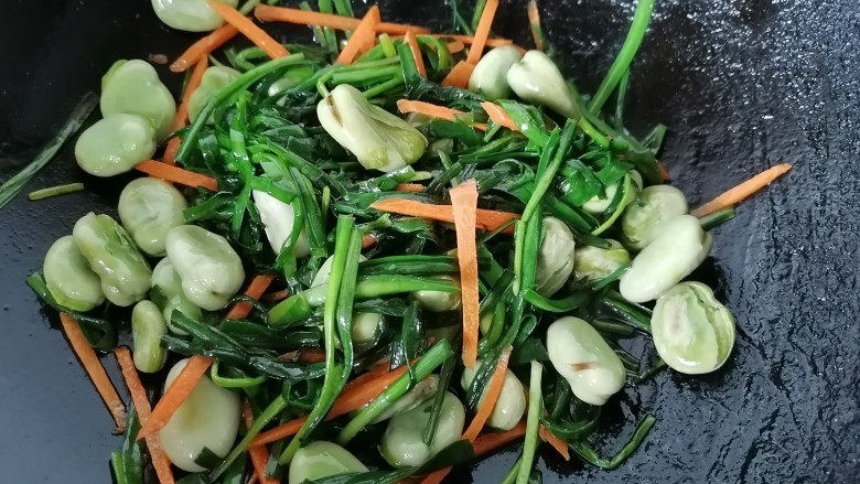 韭菜炒蚕豆,最后放入胡萝卜丝翻炒均匀即可出锅