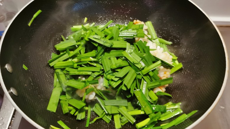 韭菜炒鱿鱼,放入韭菜叶部分翻炒。