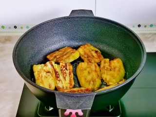 茄子盖浇饭,起油锅放入茄子中小火煎至两面金黄。