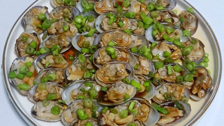 葱油花蛤,把切好的小葱末均匀的撒在花蛤肉上