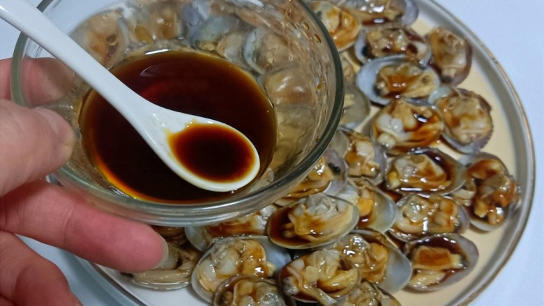 葱油花蛤,用勺子把填好的汁浇在每一个花蛤肉上。