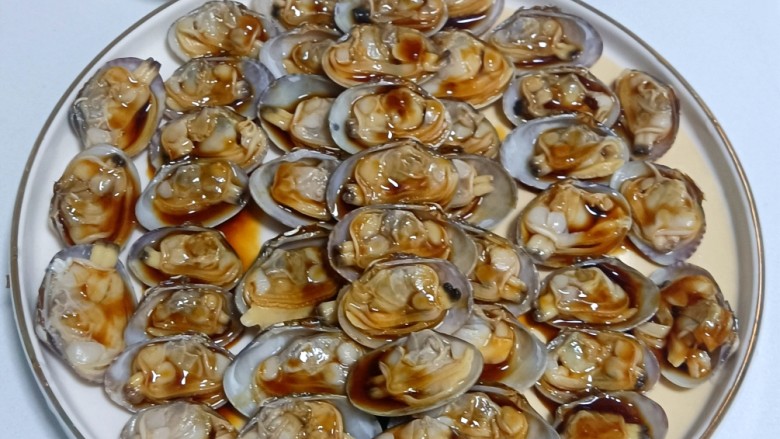 葱油花蛤,如图，确保每一个花蛤肉都蘸到汁。如果不摆盘不去空壳，这步就浇不匀。