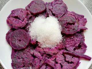 糯米紫薯糕,蒸熟的紫薯趁热加入细砂糖。 