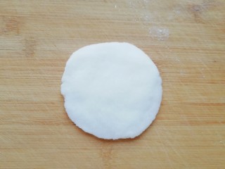 糯米紫薯糕,取一份小面团擀成中间厚边缘薄的饼皮。 