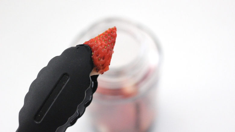 草莓蔓越莓气泡饮,把草莓块放入榨汁杯底。