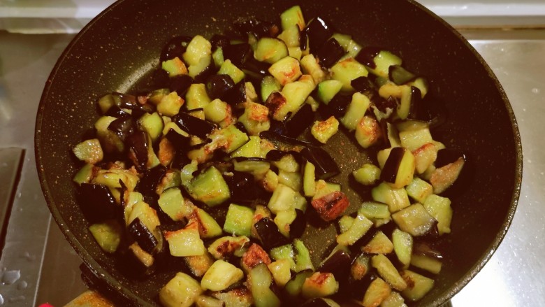 茄子盖浇饭,煎锅放入4汤匙食用油，油热后放入茄子丁煎至金黄色备用。