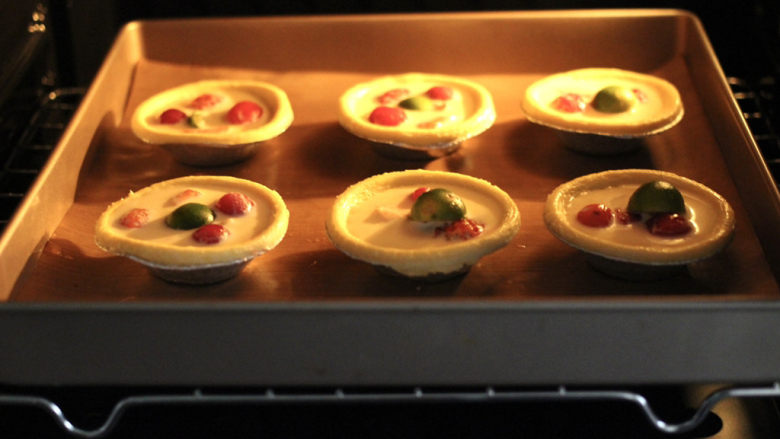 快手水果葡式蛋挞,烤箱提前预热，把蛋挞放入烤箱中层。