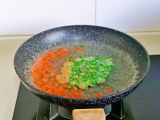 鸡蛋火腿炒饭,胡萝卜丁与蒜薹丁焯水: 锅中水烧开后，再下两丁大火煮1分钟捞出。