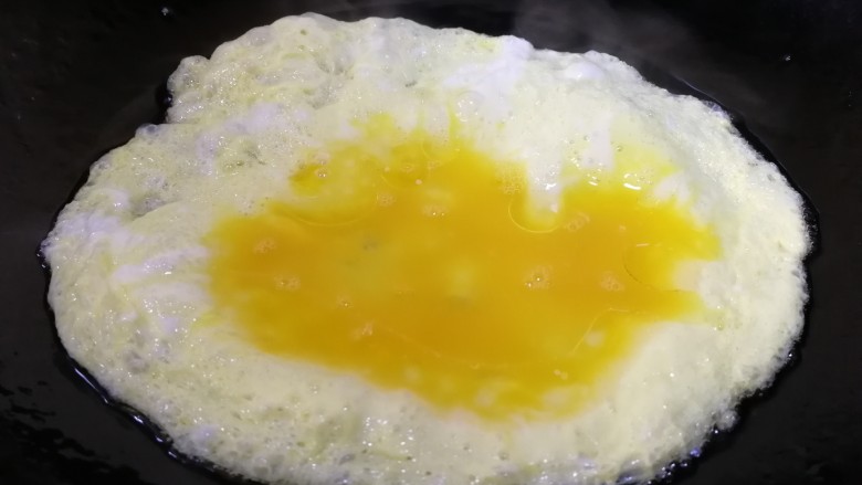 鸡蛋火腿炒饭,热锅凉油，油热倒入蛋液。