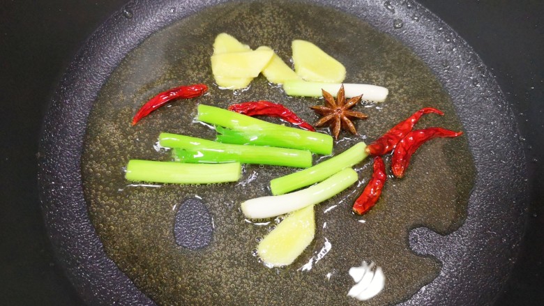 豆角牛柳,炒锅内倒适量的食用油烧热，下入葱段、姜片、干红辣椒和八角炒出香味。
