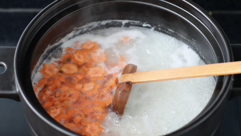 胡萝卜肉末粥,加入胡萝卜丁和小花煮5分钟。