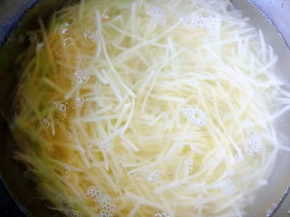 家常土豆饼,土豆丝放入清水中浸泡一会儿去除多余的淀粉后洗净