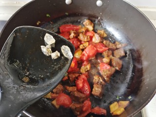 西红柿土豆炖牛肉,加入西红柿块翻炒均匀，加入冰糖块