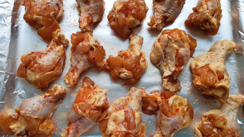 香烤翅根,烤盘里铺上锡纸，刷上一层食用油，摆上腌好的鸡翅根。 