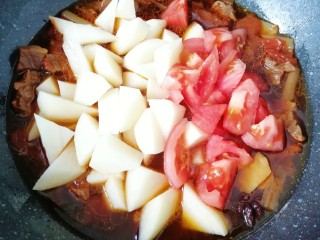 西红柿土豆炖牛肉,一个小时之后，下入土豆块和剩下的一半西红柿翻炒均匀，继续中小火炖10分钟左右(土豆熟了即可)。 