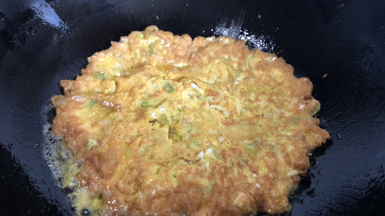 笋尖炒蛋,凝固后翻面，煎至两面金黄。
