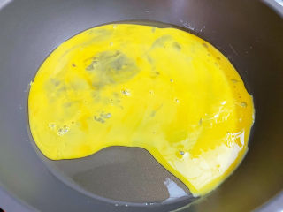 鸡蛋火腿炒饭,锅中倒入适量的食用油烧热，倒入蛋液