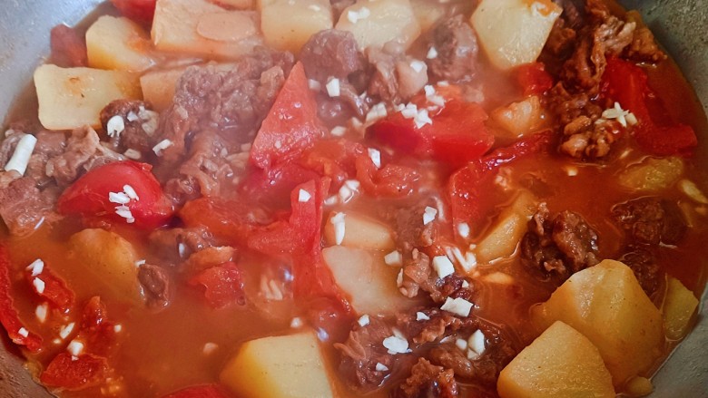 西红柿土豆炖牛肉,西红柿汤汁都炖出来了，尝一下咸淡，最后撒蒜末，味精出锅。