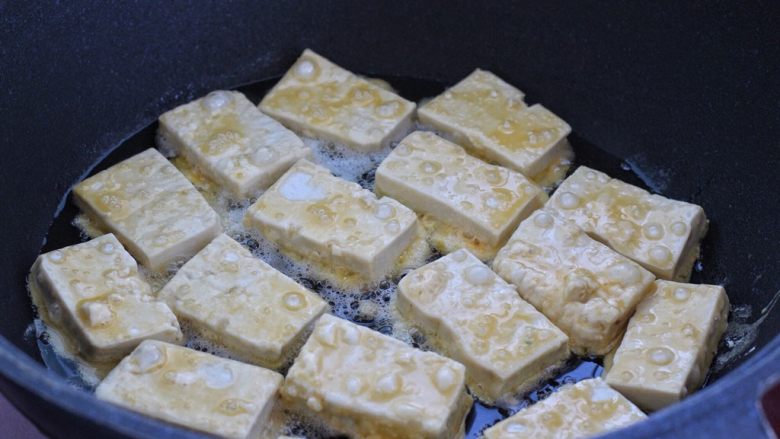 干煸豆腐,平底锅中倒适量食用油烧热，依次放入豆腐块开小火煎制。