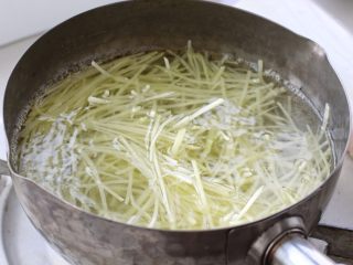 家常土豆饼,切好的土豆丝用清水冲洗掉表面淀粉成分，然后放到开水中焯烫一分钟左右。