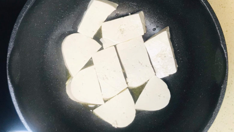 干煸豆腐,将老豆腐整齐地摆放在锅里
