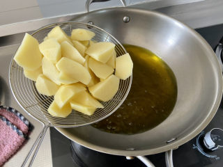 家常地三鲜,锅中加宽油，油六成热，下沥水的土豆块，
