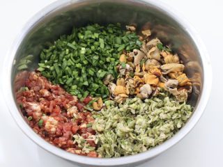 槐花海虹肉丁饺子,加入槐花和切碎的韭菜，海虹肉提前用刀一切两半也加入盆里。