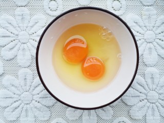 鸡蛋火腿炒饭,鸡蛋磕入碗中。