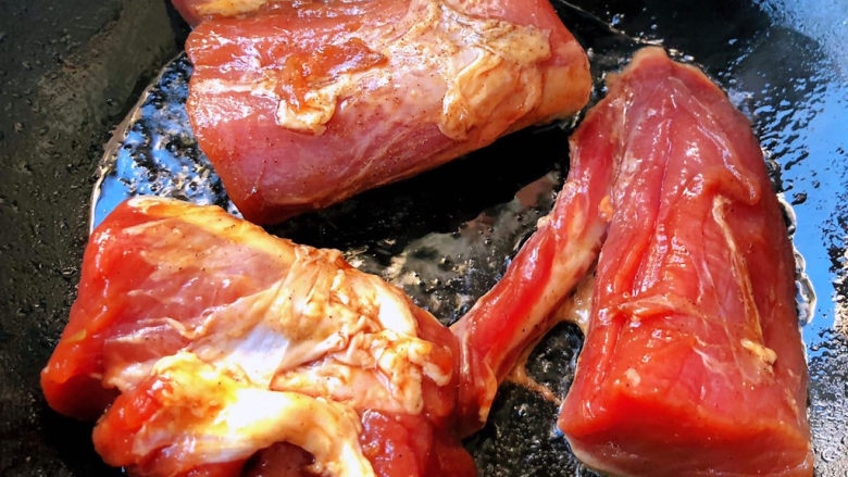 叉烧里脊肉,锅中倒入底油加热放入入味的里脊肉中火煎制
