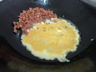 鸡蛋火腿炒饭,把火腿丁弄一边，加入鸡蛋液煎熟翻炒一下