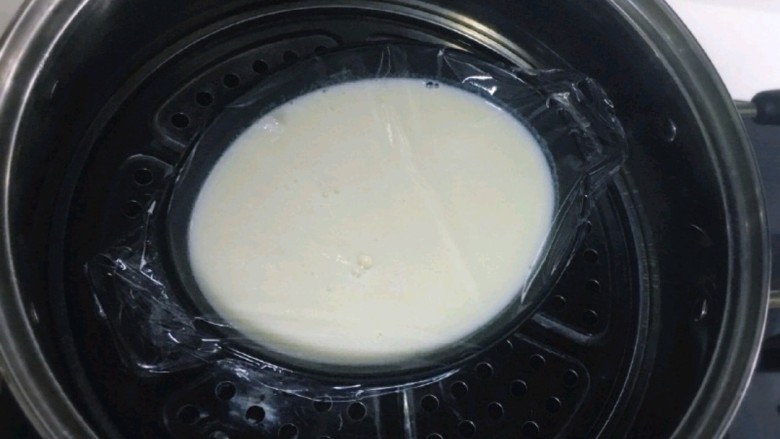 芒果双皮奶,盖上保鲜膜（在保鲜膜上扎几个小洞），准备一个大锅倒入足量的清水，大火烧开，放入蛋奶液，中火蒸10分钟即可。