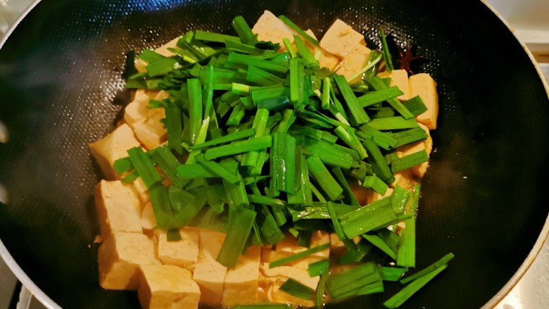 韭菜豆腐,汤汁所剩无几时，放入韭菜翻炒。