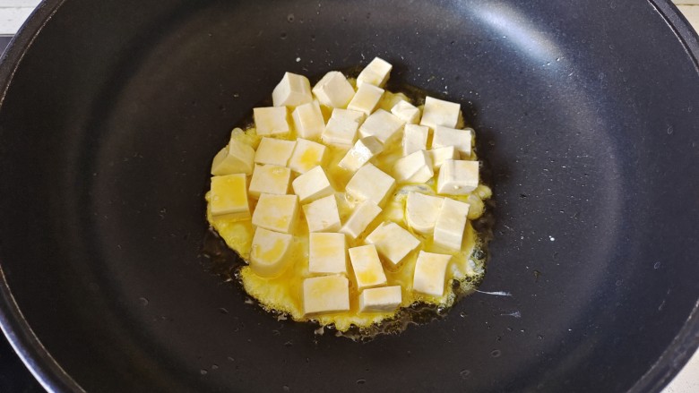 韭菜豆腐,锅中加入适量花生油烧热，放入豆腐煎
