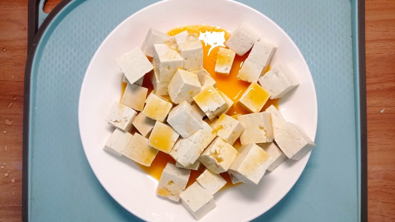 韭菜豆腐,将蛋液淋在豆腐上，轻轻的搅拌均匀，尽量让豆腐都沾上蛋液