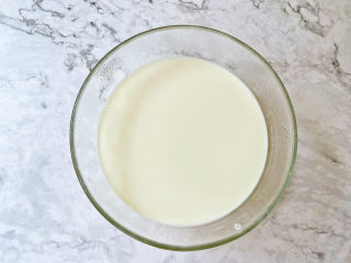芒果双皮奶,等牛奶冷却后，用筷子轻轻挑起一侧奶皮，小心的将牛奶倒入蛋清中，不要全部倒完，小碗中留下少许牛奶，这样奶皮才不会粘在碗上，否则不会乳起来