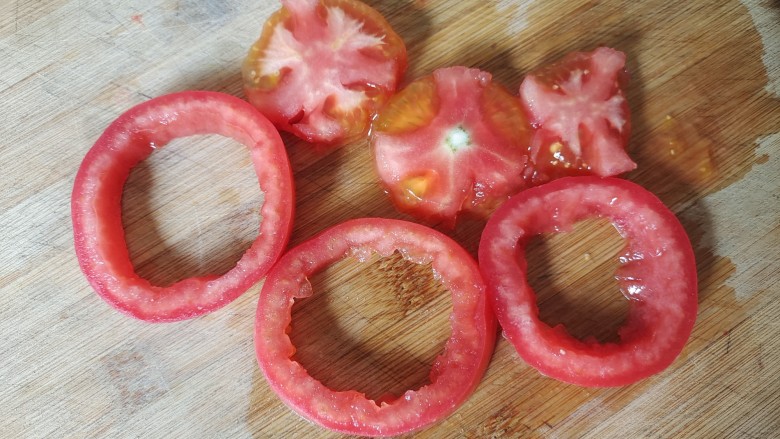 煎西红柿,用勺子把西红柿中间挖出来